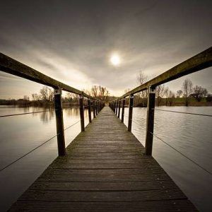 Small wooden bridge over flooded river.